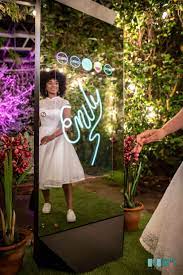 Guest posing in the mirror booth at an outdoor garden event