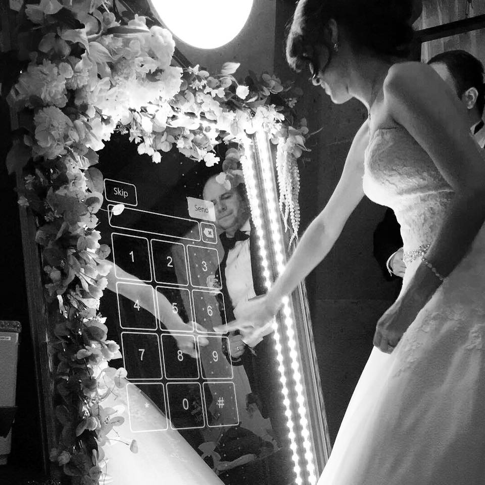 Bride using the mirror booth touchscreen at her wedding